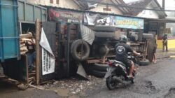 Diduga Akibat Jalan Rusak, Truk Muatan Kayu Terguling di Parungkuda Sukabumi