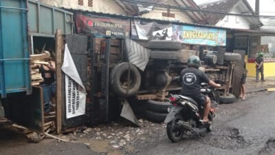 Diduga Akibat Jalan Rusak, Truk Muatan Kayu Terguling di Parungkuda Sukabumi